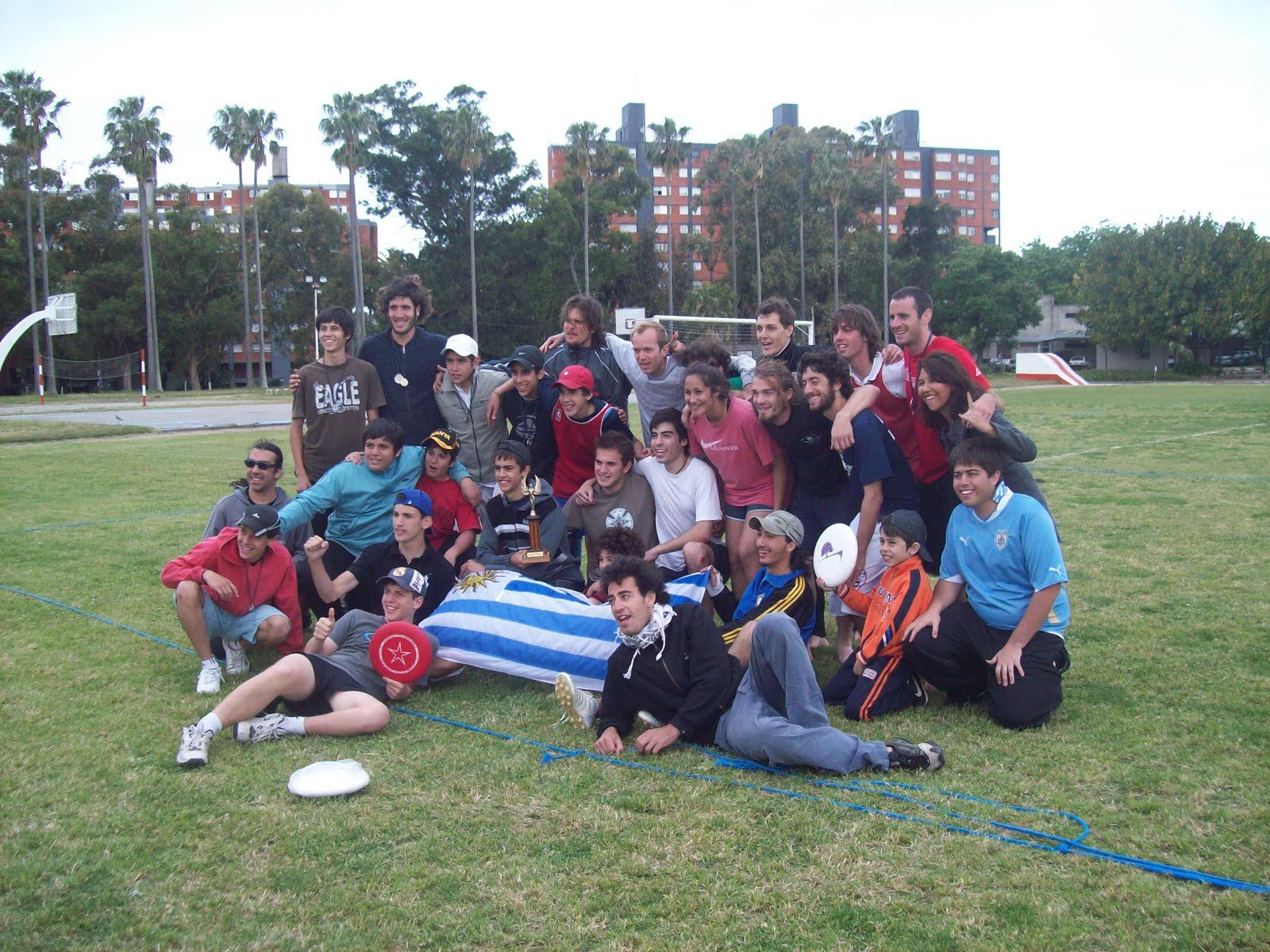Grupo de jugadores del primer Hat Charrúa, en 2010, posando en la cancha con discos y una bandera de Uruguay