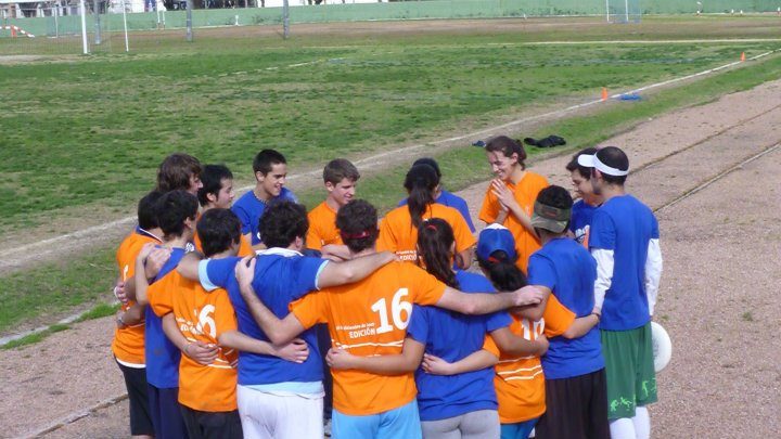 Equipo mixto del Hat Charrúa 2011 en un círculo, con remeras naranjas y azules