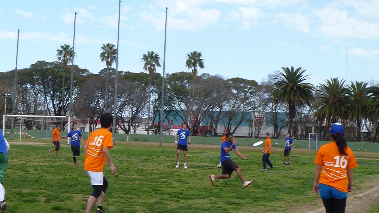 Jugadores de remera naranja y azul disputando un disco durante el Hat Charrúa 2011
