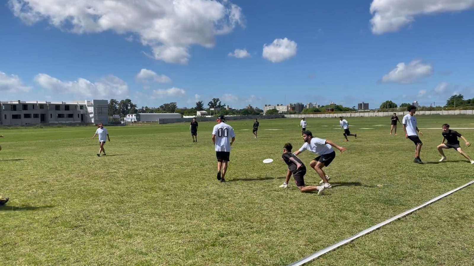 Jugadores de remera blanca y negra disputando un punto en el Hat Charrúa 2024